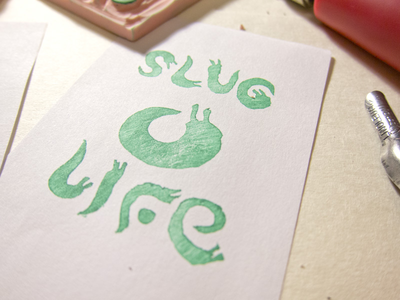 stamp with the text "SLUG LIFE" spelled out with slugs for letters